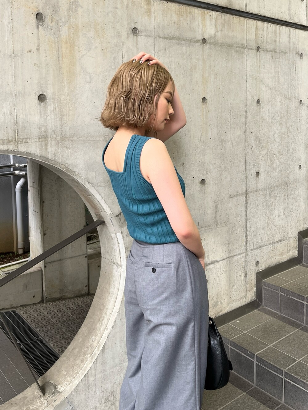 ブルー系のタンクトップ、グレー系のその他パンツ、ブラック系のハンドバッグを着用したレディースの夏コーディネートの4枚目の写真