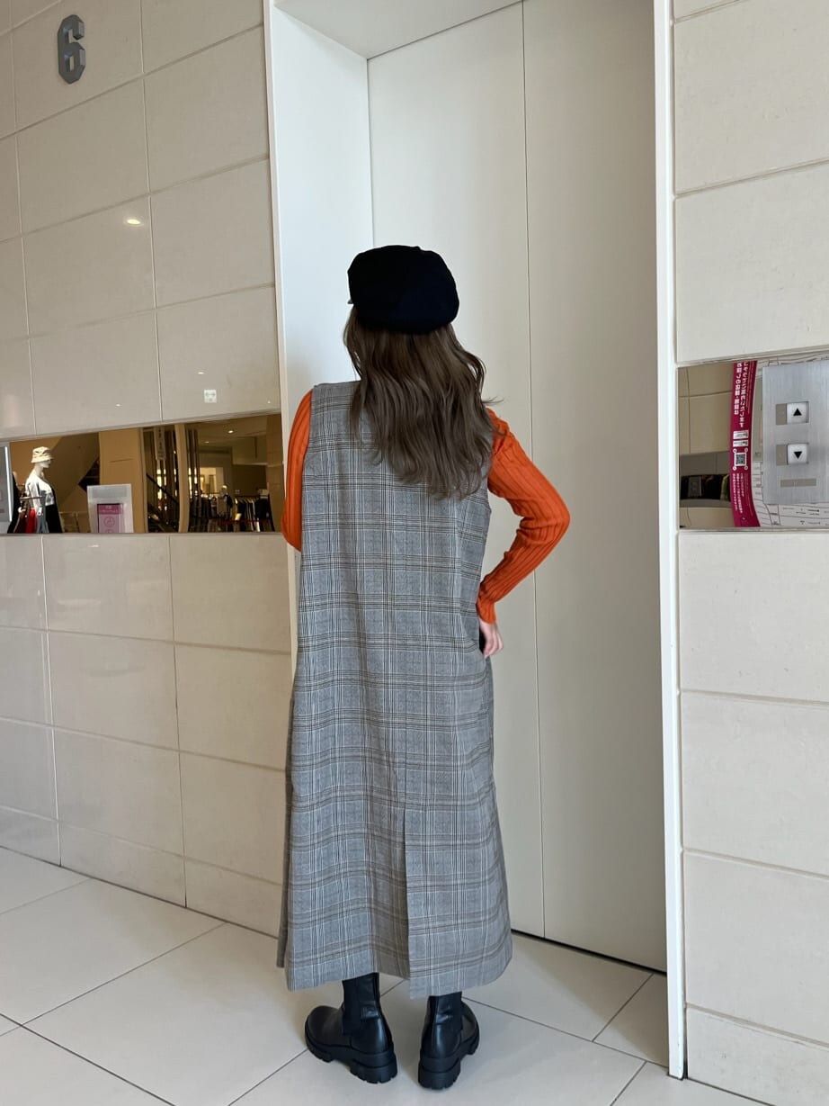 ブラック系のブーツ、オレンジ系のニット/セーター、ゴールド系のネックレスを着用したレディースの秋コーディネートの4枚目の写真