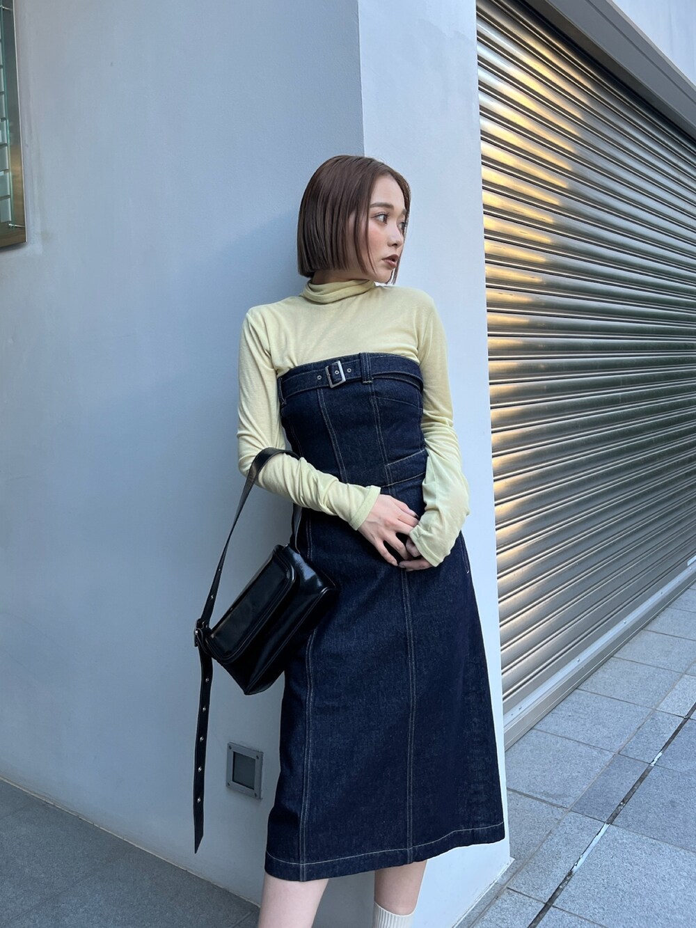 ブルー系のワンピース、ホワイト系のブーツ、イエロー系のTシャツ/カットソーを着用したレディースの秋コーディネートの4枚目の写真