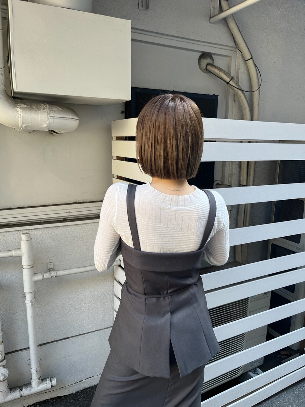 グレー系のシャツ/ブラウス、グレー系のスカート、ホワイト系のニット/セーターを着用したレディースの冬コーディネートの7枚目の写真