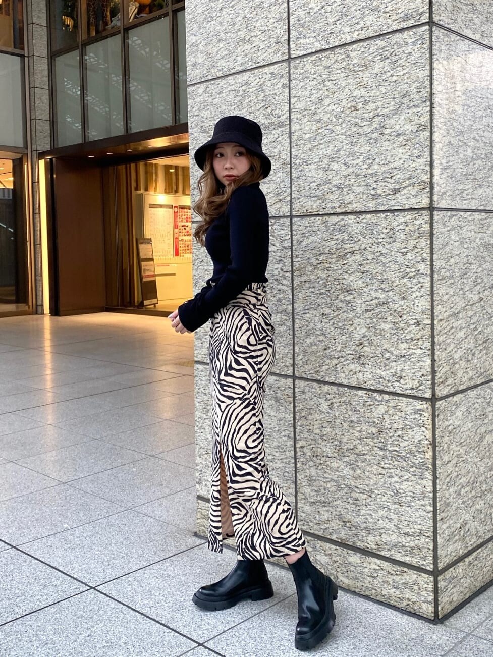 ブラック系のブーツ、その他のスカート、ブラック系のニット/セーターを着用したレディースの春コーディネートの2枚目の写真