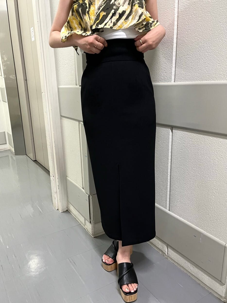 ブラック系のサンダル、ブラック系のスカート、ホワイト系のタンクトップを着用したレディースの夏コーディネートの6枚目の写真