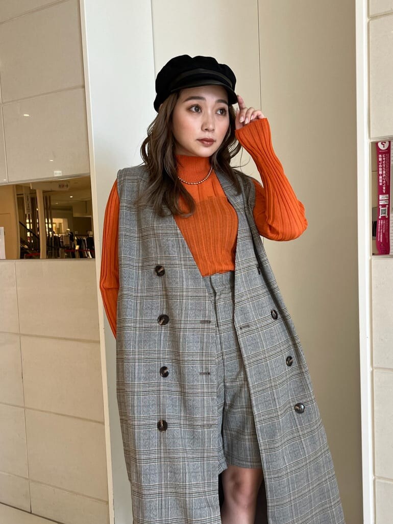 ブラック系のブーツ、オレンジ系のニット/セーター、ゴールド系のネックレスを着用したレディースの秋コーディネートの5枚目の写真