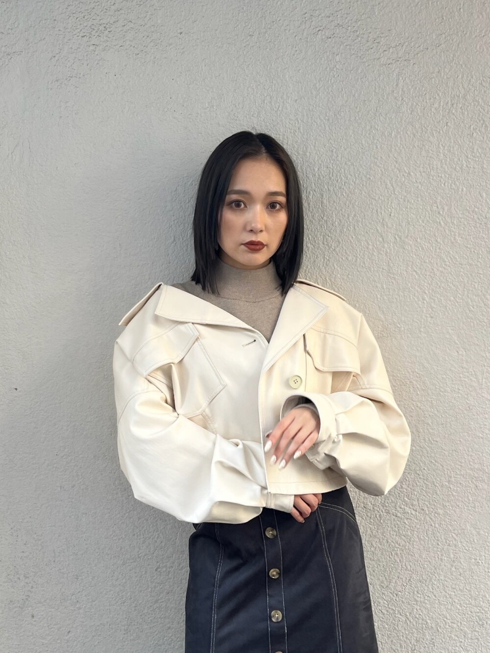 ベージュ系のニット/セーター、ホワイト系のブルゾン、ブラック系のブーツを着用したレディースの夏コーディネートの2枚目の写真