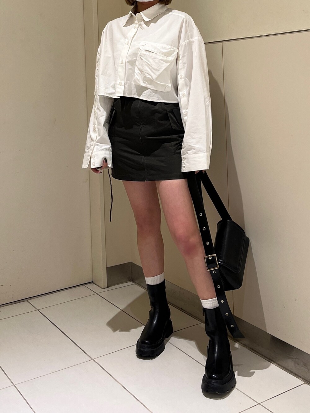 ホワイト系のシャツ/ブラウス、グリーン系のスカート、ブラック系のブーツを着用したレディースの冬コーディネートの3枚目の写真