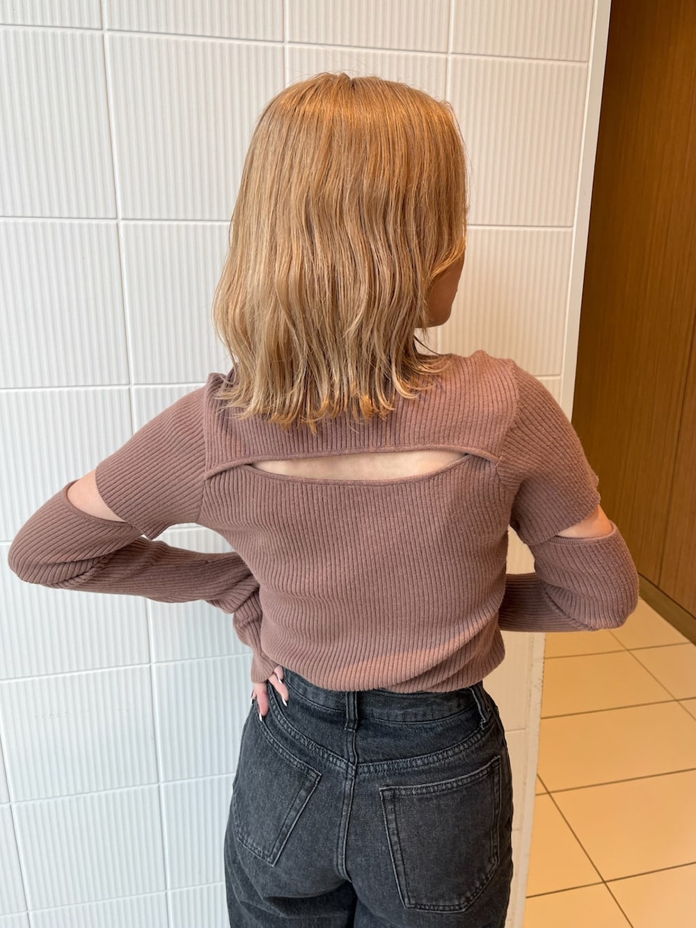 ブラック系のデニムパンツ、ブラウン系のニット/セーター、ブラック系のブーツを着用したレディースの冬コーディネートの6枚目の写真