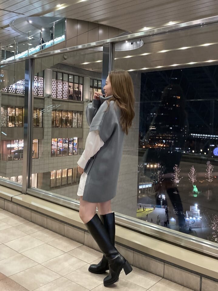 ホワイト系のハンドバッグ、ブラック系のブーツ、ブルー系のワンピースを着用したレディースの冬コーディネートの4枚目の写真