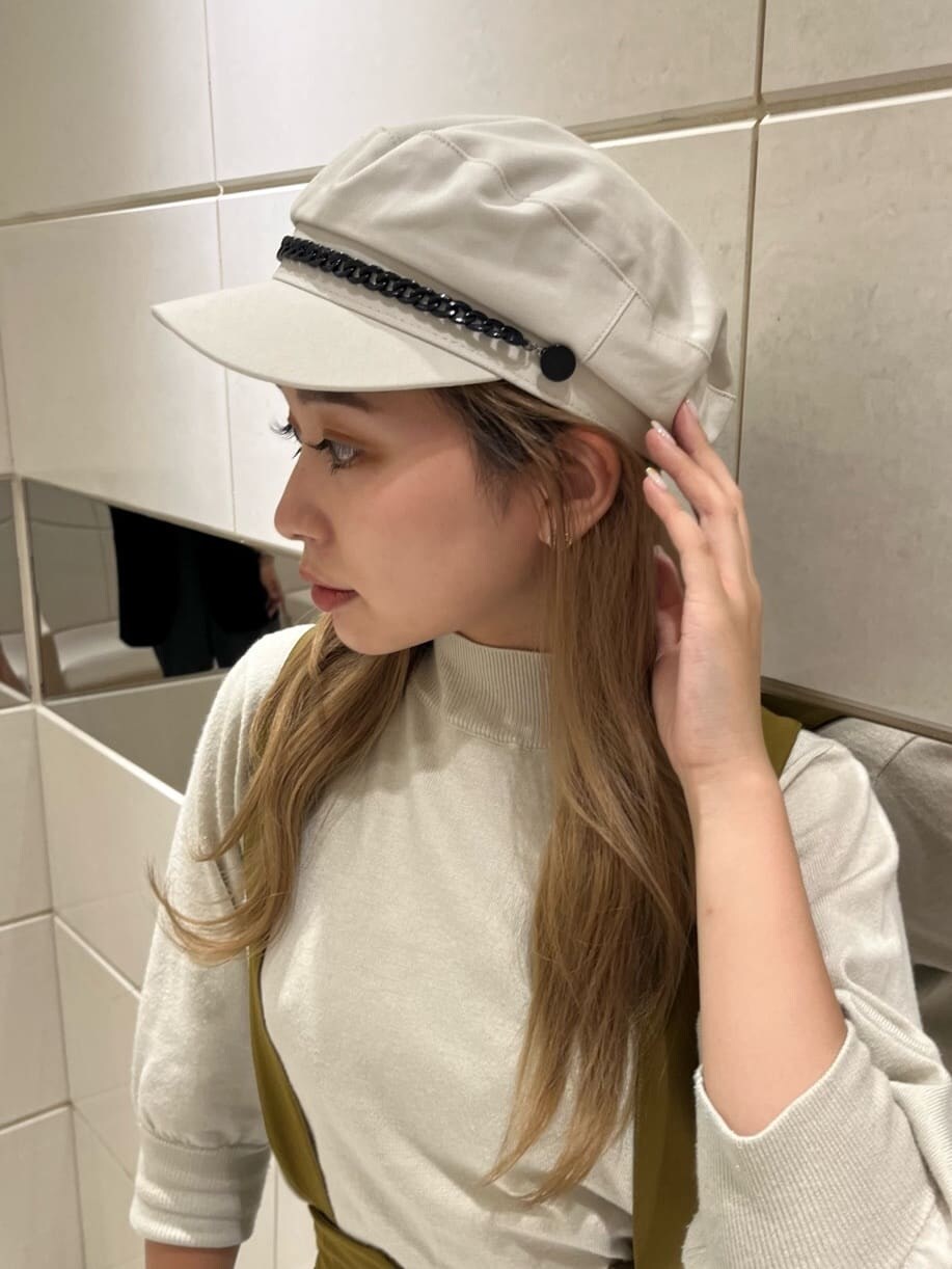 イエロー系のワンピース、ブラック系のブーツ、ホワイト系のニット/セーターを着用したレディースの秋コーディネートの7枚目の写真