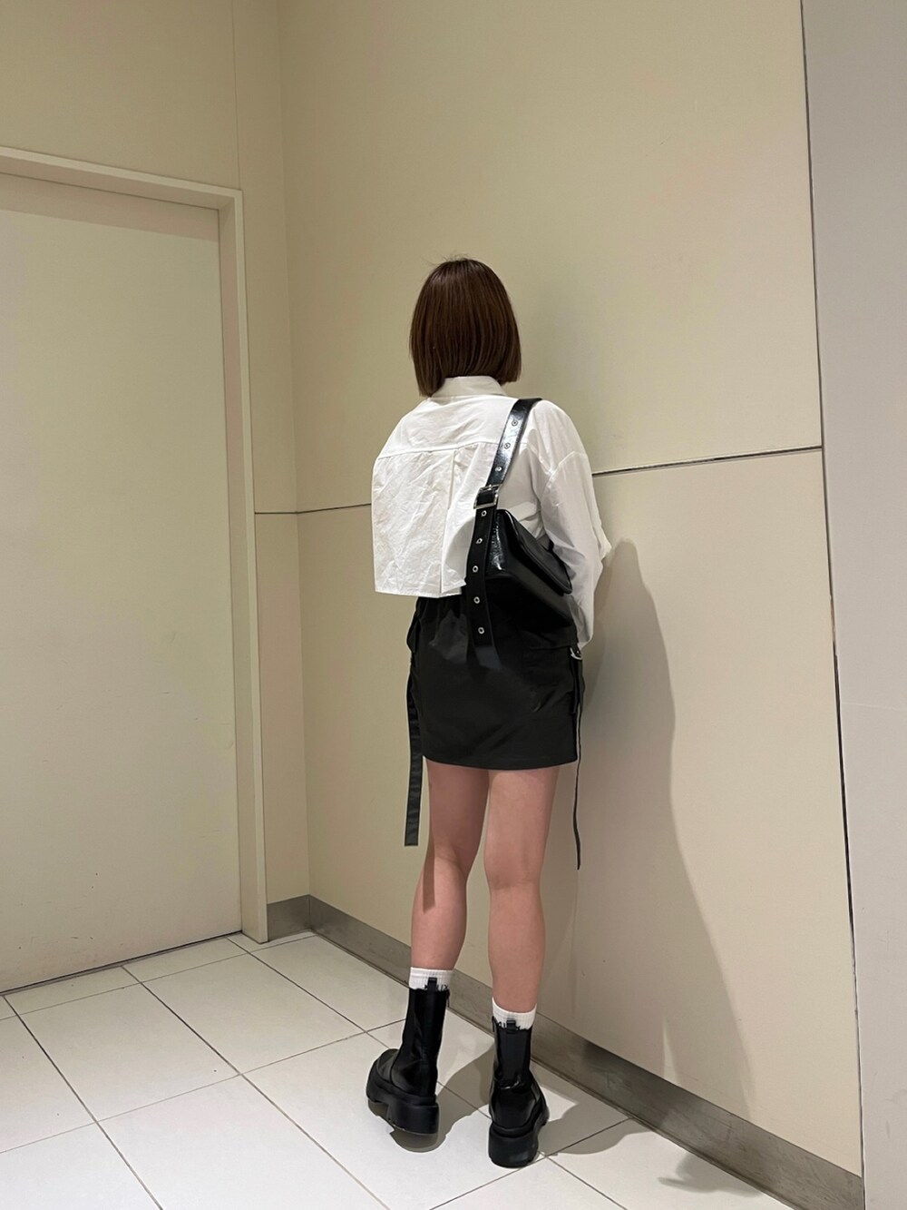 ホワイト系のシャツ/ブラウス、グリーン系のスカート、ブラック系のブーツを着用したレディースの冬コーディネートの2枚目の写真