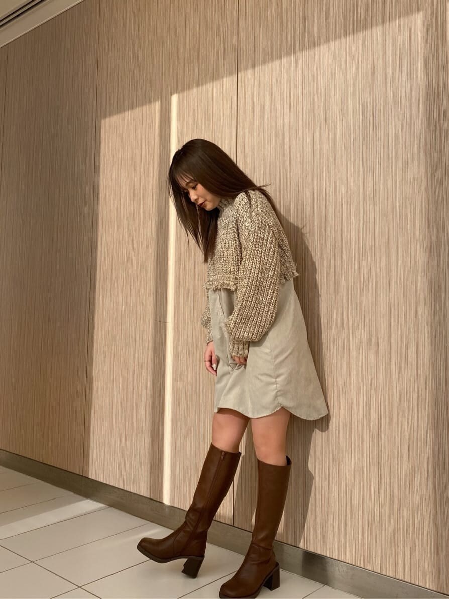 ブラック系のブーツ、ホワイト系のワンピースを着用したレディースの冬コーディネートの2枚目の写真