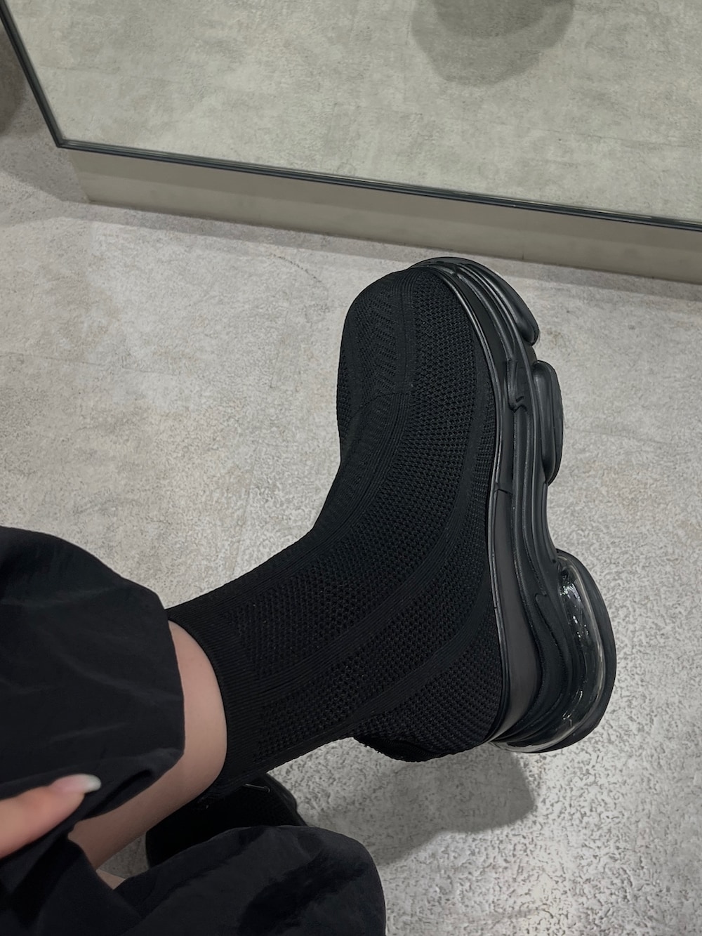 ブラック系のスカート、ブラック系のブーツ、グリーン系のTシャツ/カットソーを着用したレディースの春コーディネートの4枚目の写真