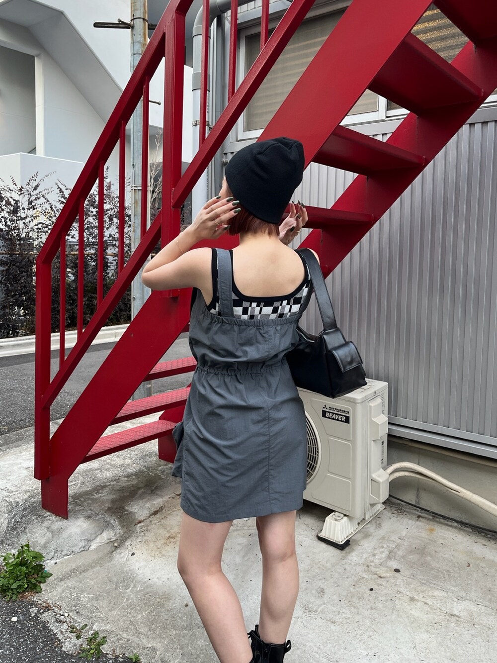 グレー系のワンピース、ブラック系のブーツ、ブラック系のタンクトップを着用したレディースの春コーディネートの6枚目の写真