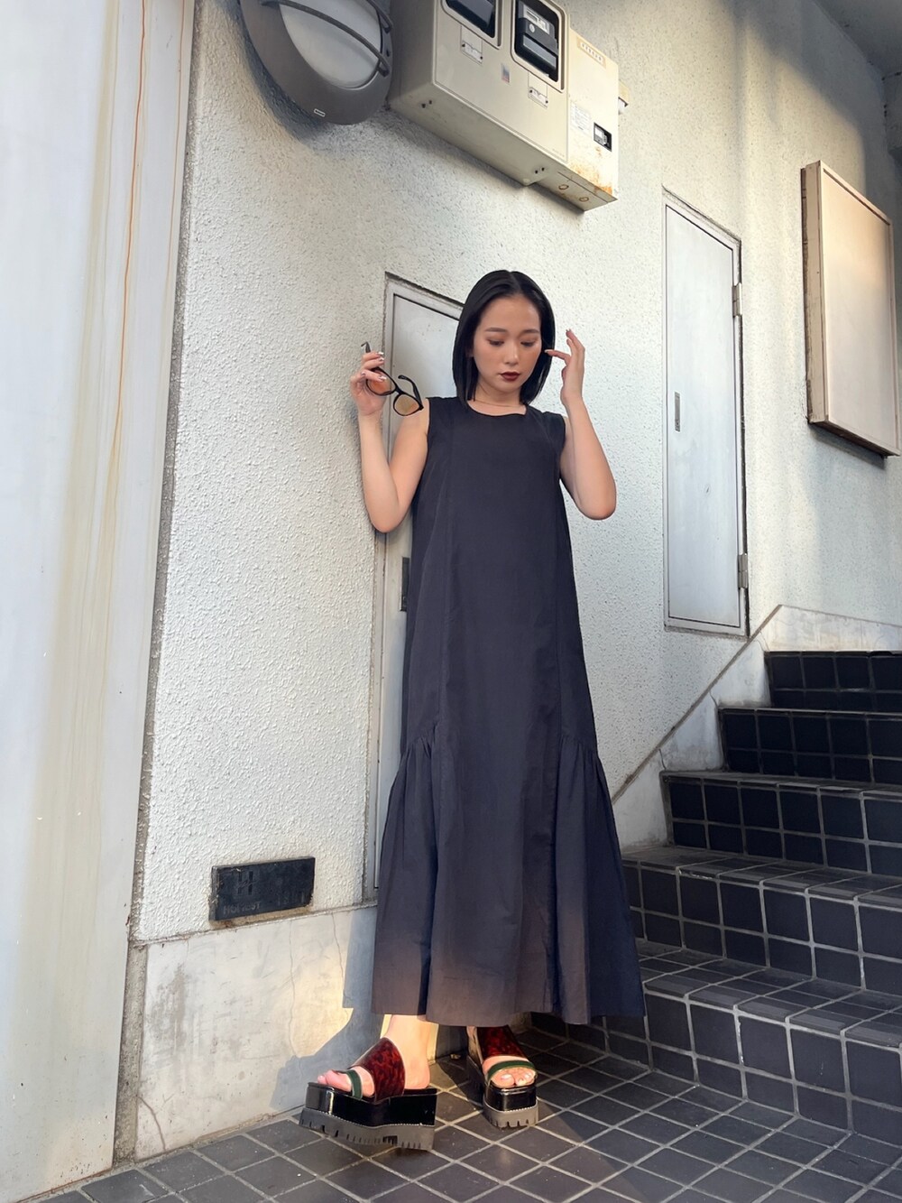 ブラック系のワンピース、その他のサンダルを着用したレディースの夏コーディネートの3枚目の写真
