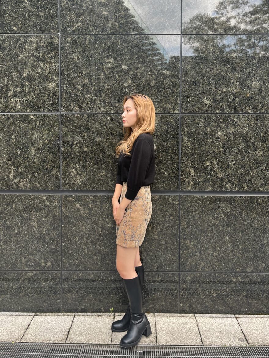 ブラック系のブーツ、ブラック系のニット/セーター、ブラウン系のスカートを着用したレディースの秋コーディネートの3枚目の写真