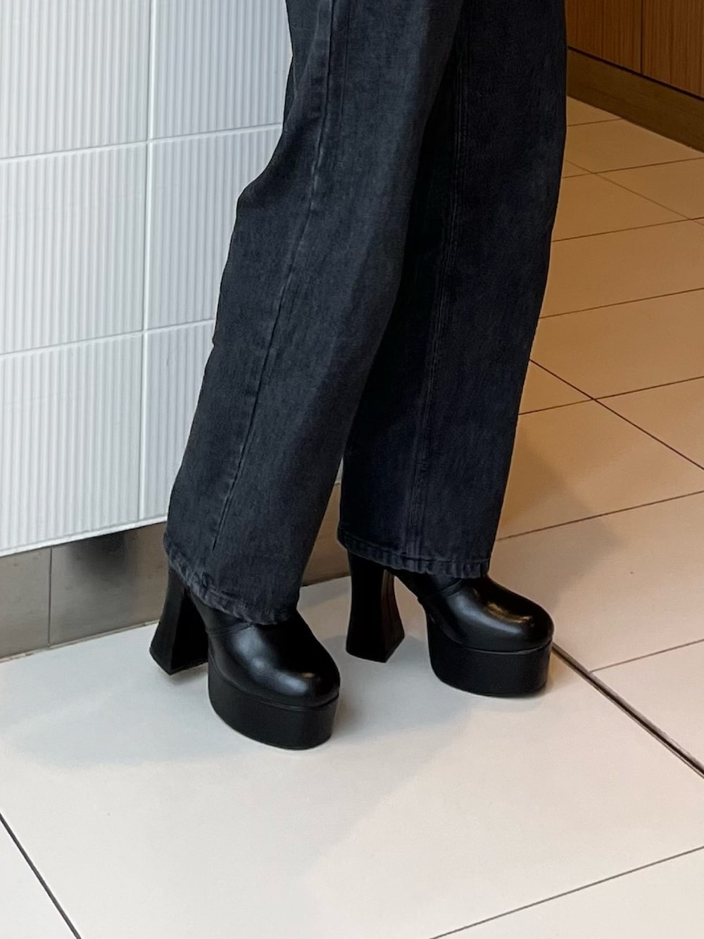 ブラック系のデニムパンツ、ブラウン系のニット/セーター、ブラック系のブーツを着用したレディースの冬コーディネートの9枚目の写真