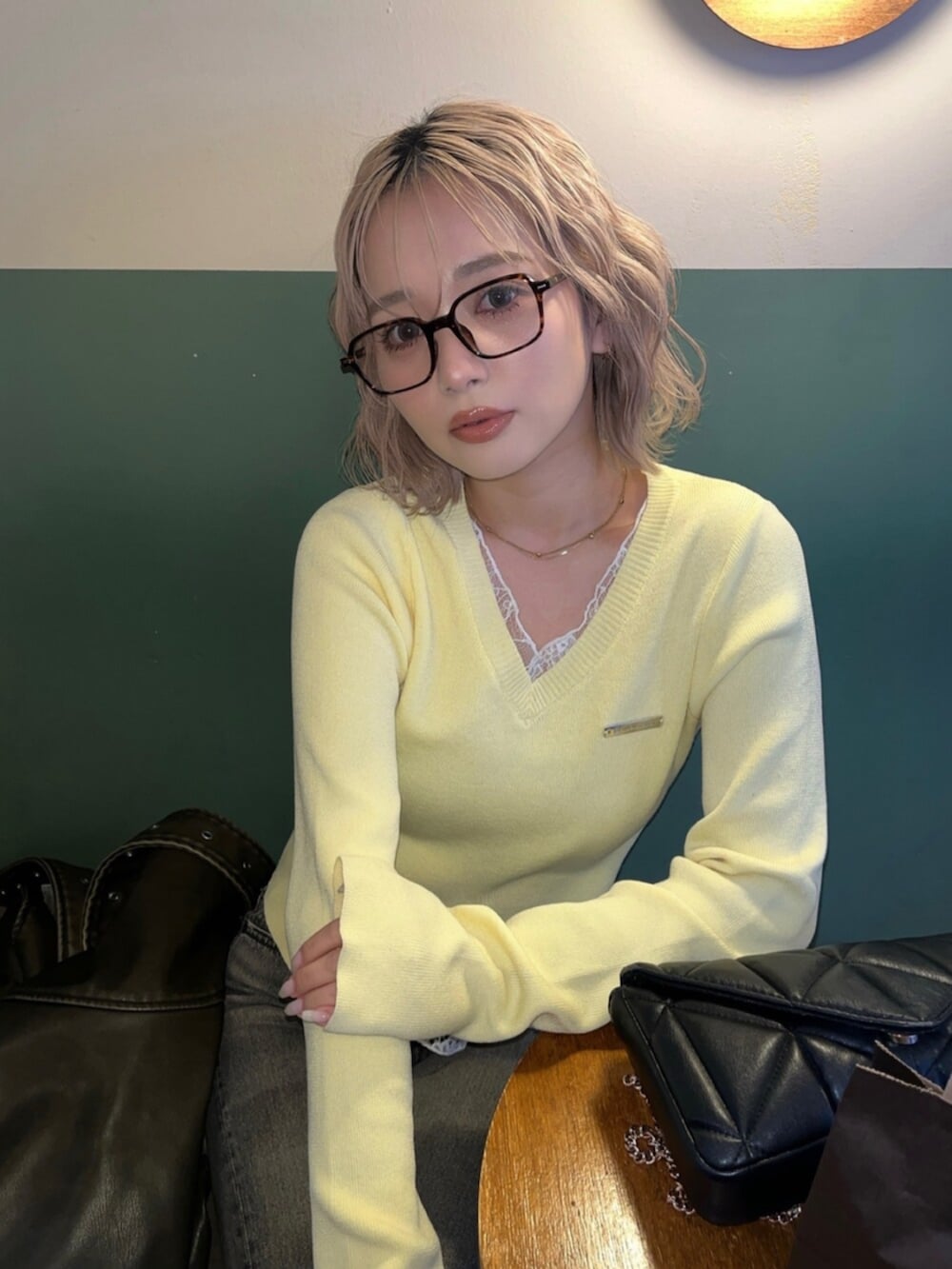 ブラック系のブーツ、イエロー系のニット/セーターを着用したレディースの春コーディネートの4枚目の写真