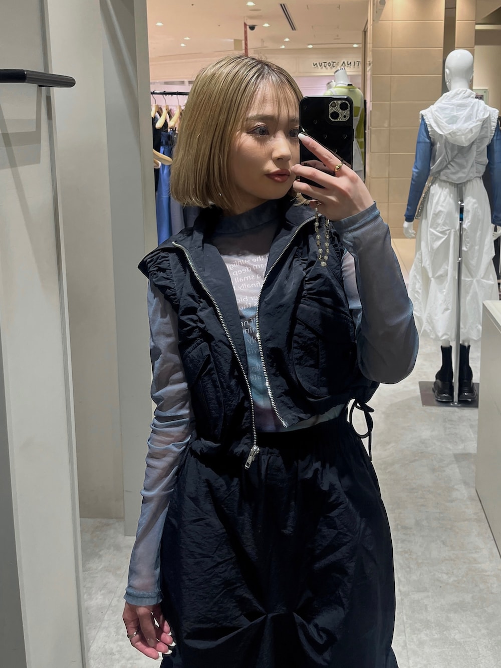 ブラック系のスカート、ブラック系のブーツ、グリーン系のTシャツ/カットソーを着用したレディースの春コーディネートの2枚目の写真