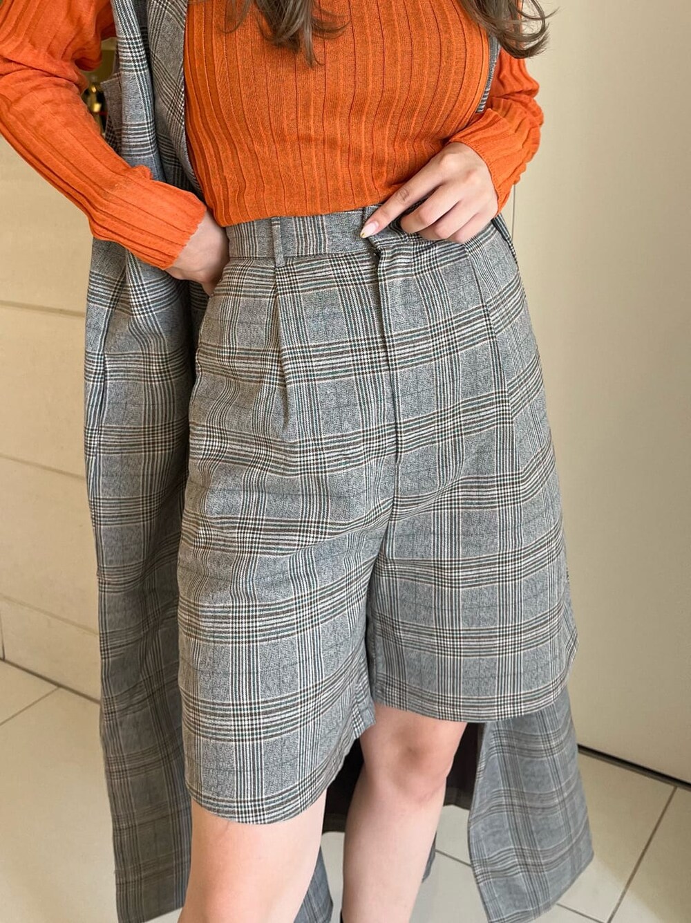 ブラック系のブーツ、オレンジ系のニット/セーター、ゴールド系のネックレスを着用したレディースの秋コーディネートの7枚目の写真