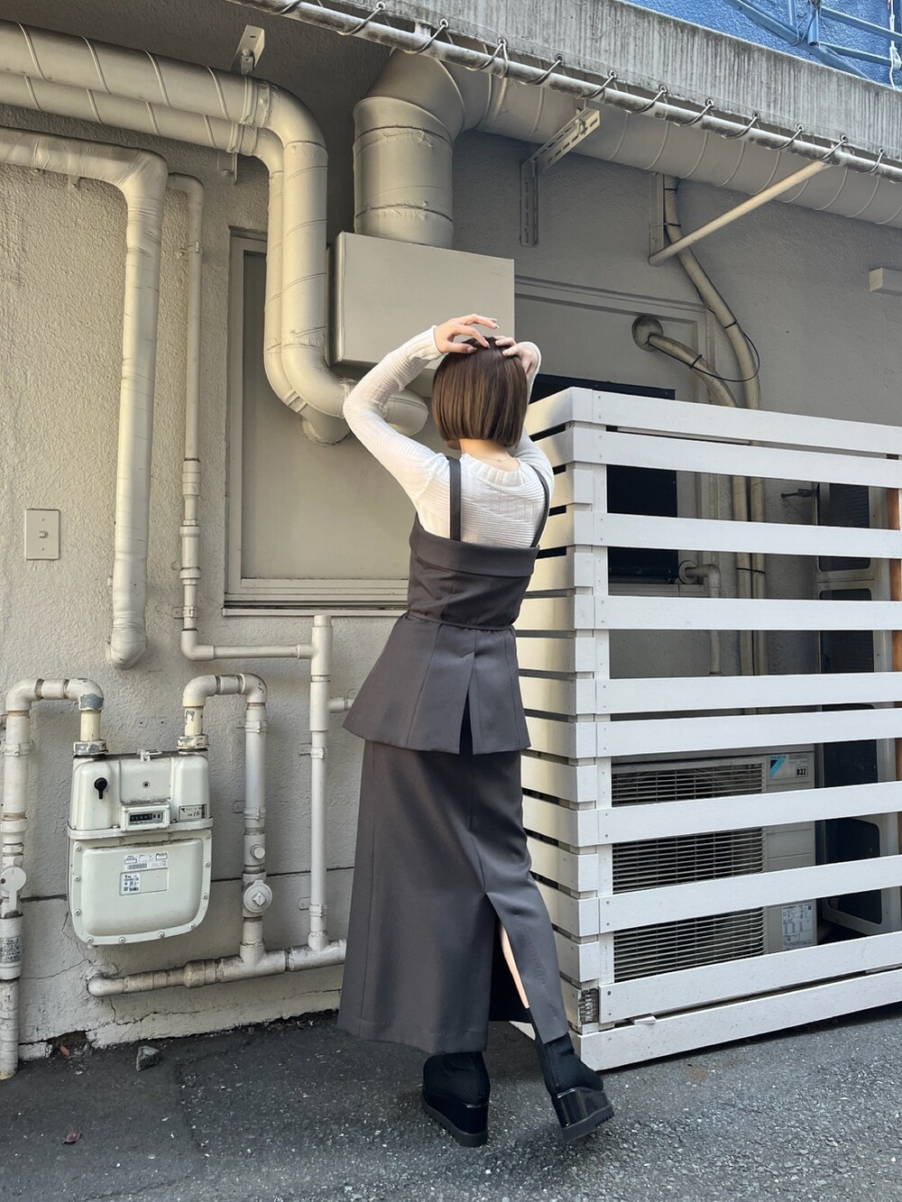 グレー系のシャツ/ブラウス、グレー系のスカート、ホワイト系のニット/セーターを着用したレディースの冬コーディネートの2枚目の写真