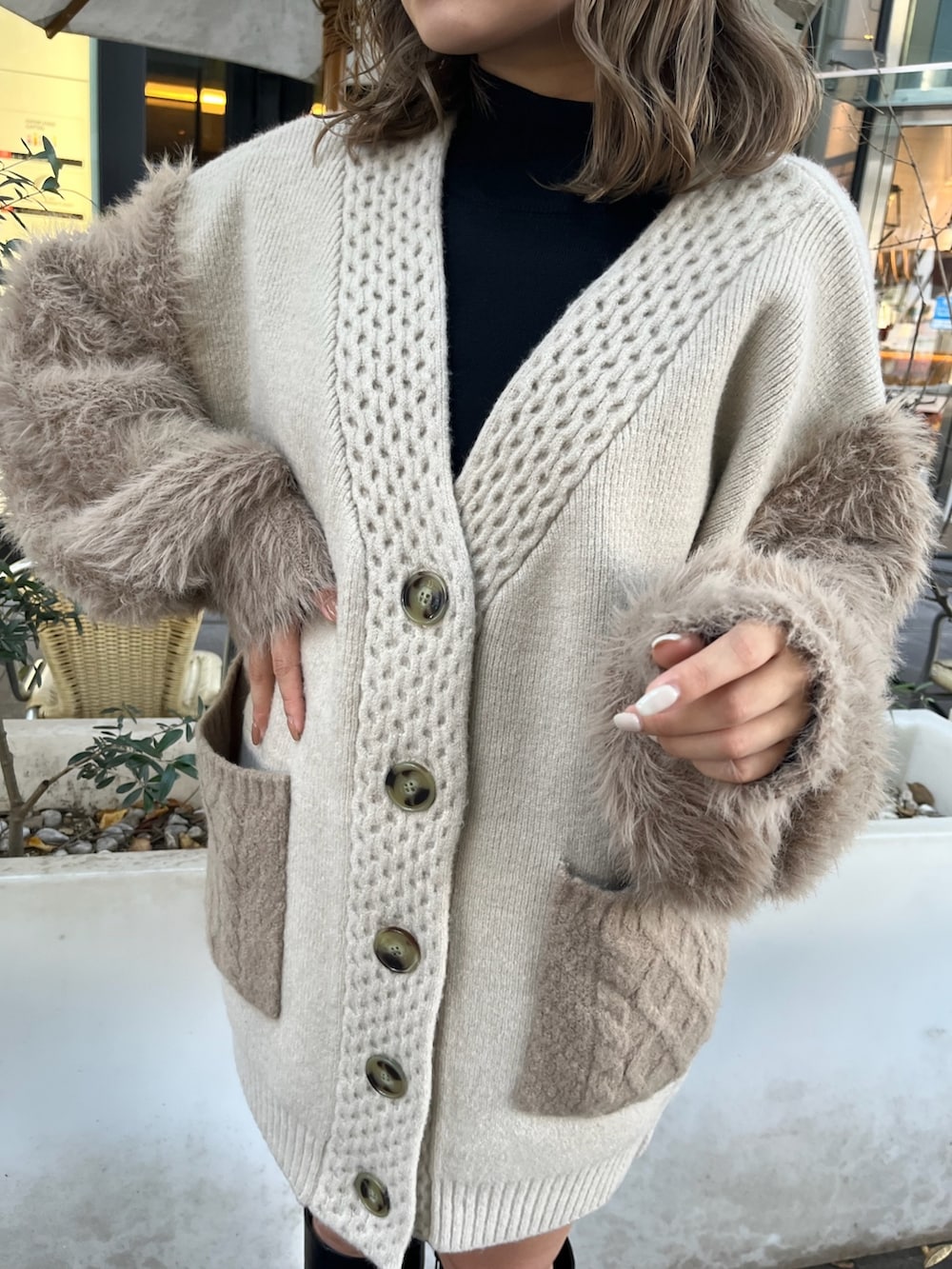 ベージュ系のカーディガン/ボレロ、ブラック系のニット/セーター、ブラック系のブーツを着用したレディースの秋コーディネートの8枚目の写真