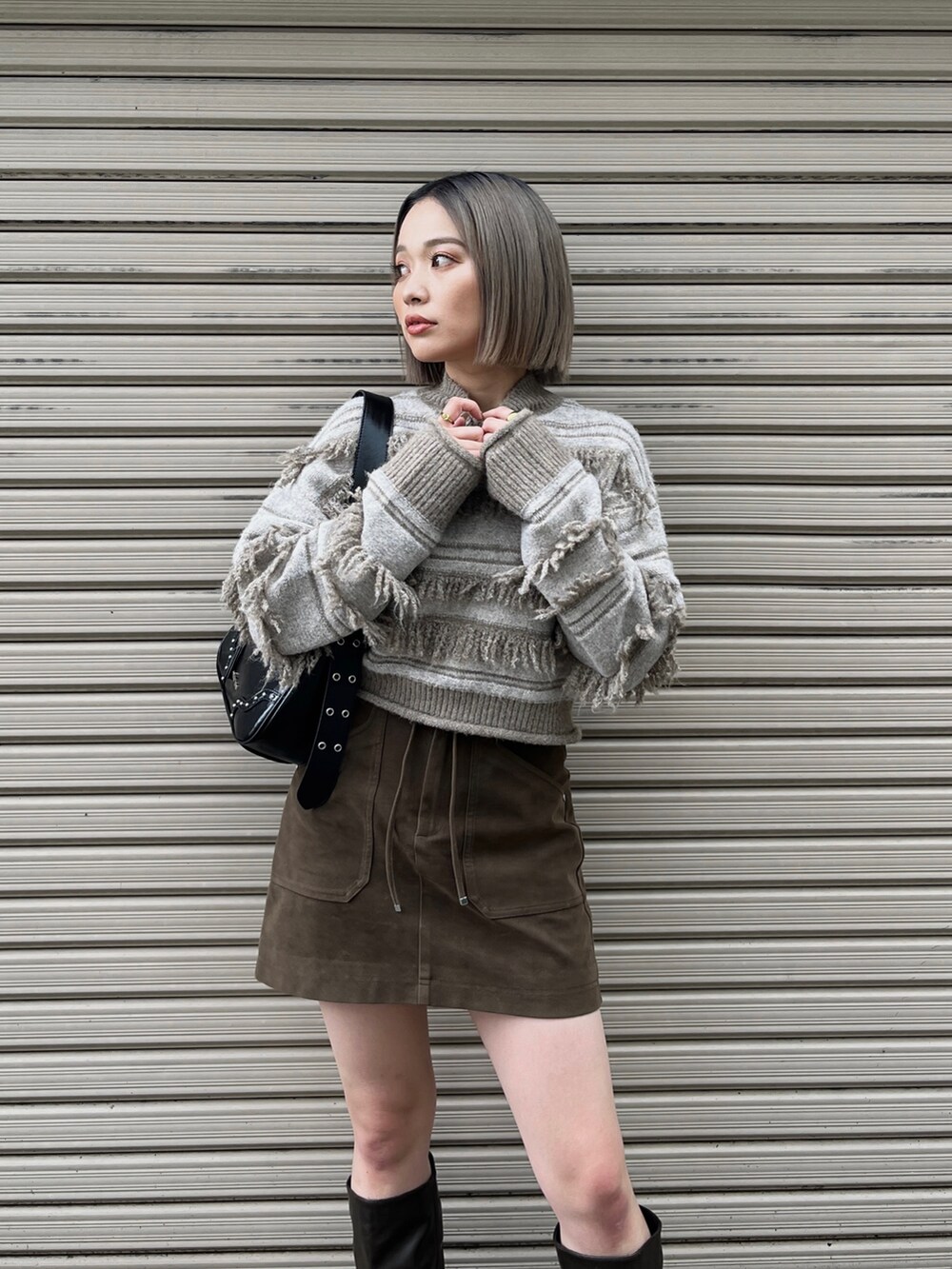 ホワイト系のニット/セーター、ブラック系のハンドバッグ、ブラウン系のスカートを着用したレディースの秋コーディネートの3枚目の写真