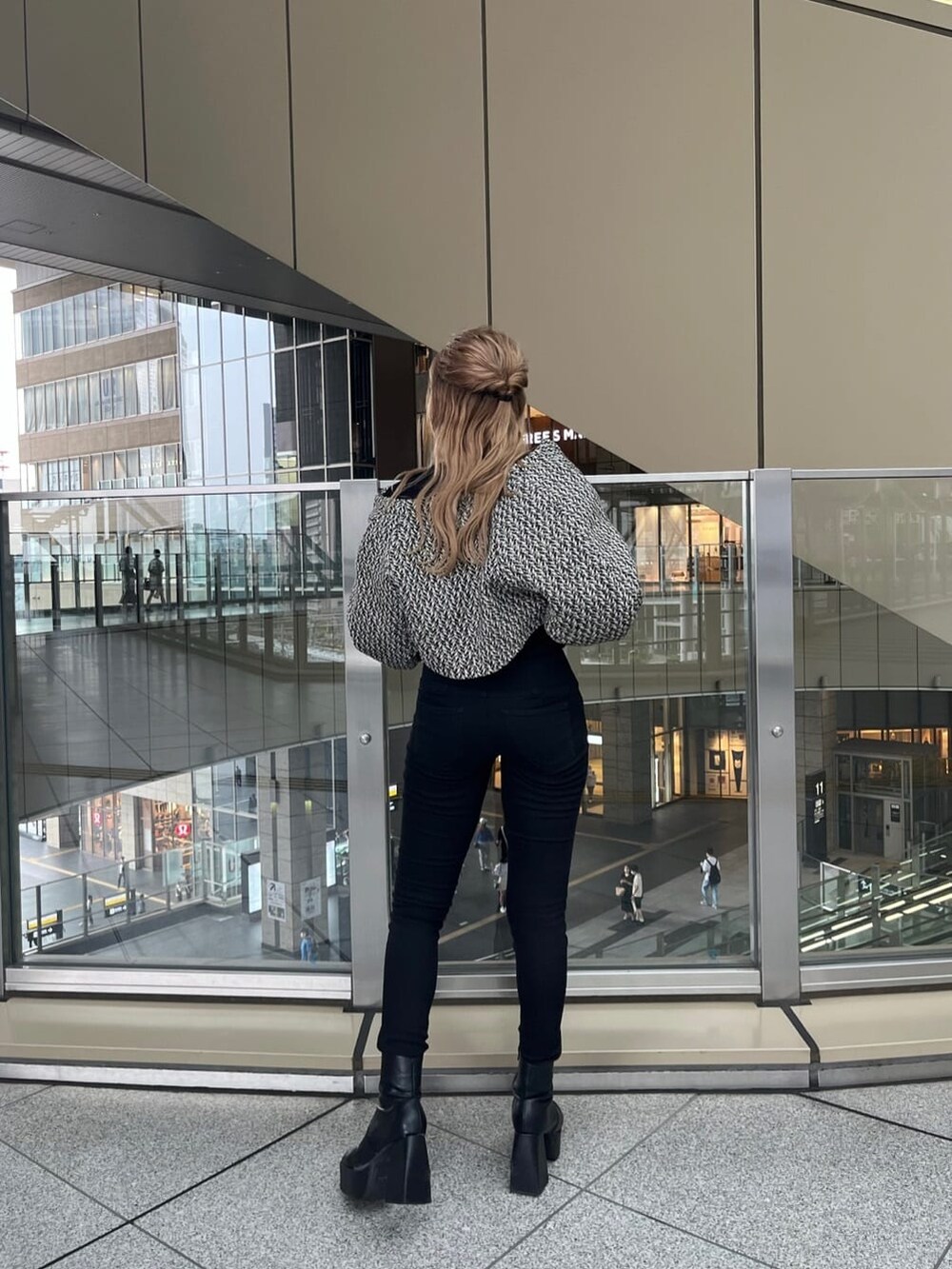 ブラック系のデニムパンツ、ブラック系のニット/セーター、ベージュ系のトレンチコートを着用したレディースの夏コーディネートの8枚目の写真