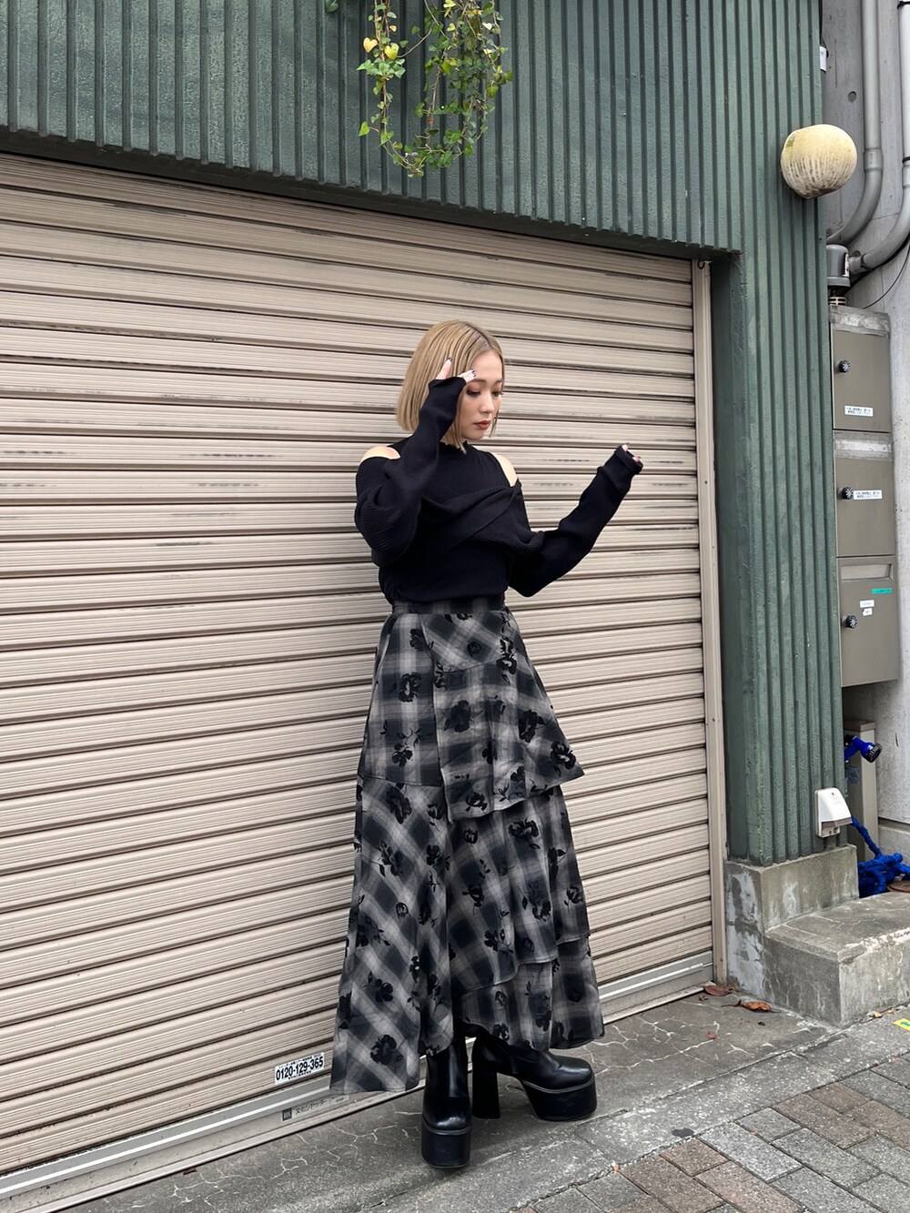 ブラック系のニット/セーター、ブラック系のスカート、ホワイト系のトートバッグを着用したレディースの冬コーディネートの2枚目の写真