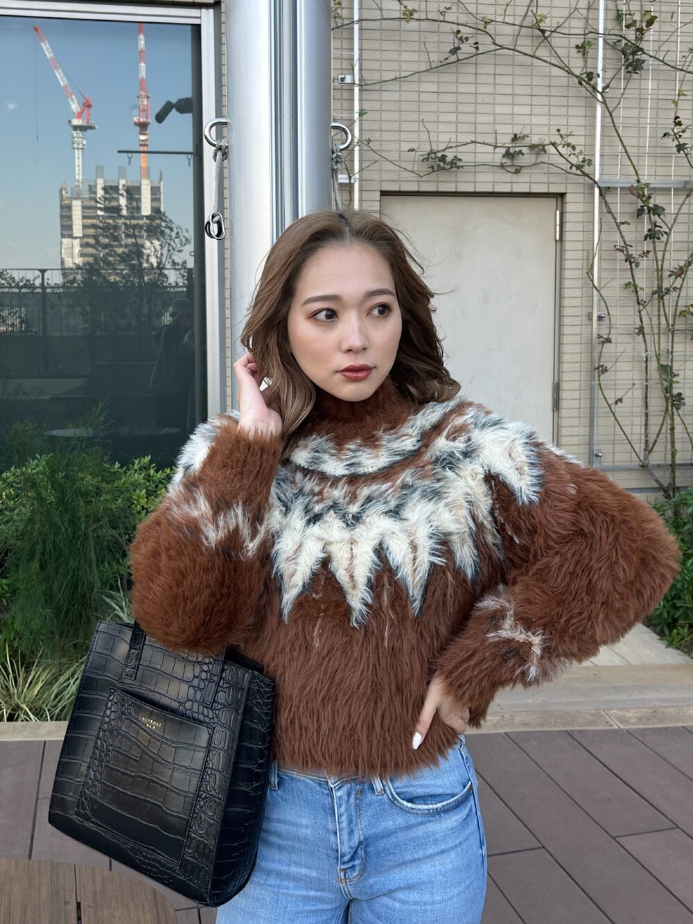 ブラウン系のニット/セーター、ブラック系のブーツを着用したレディースの冬コーディネートの4枚目の写真