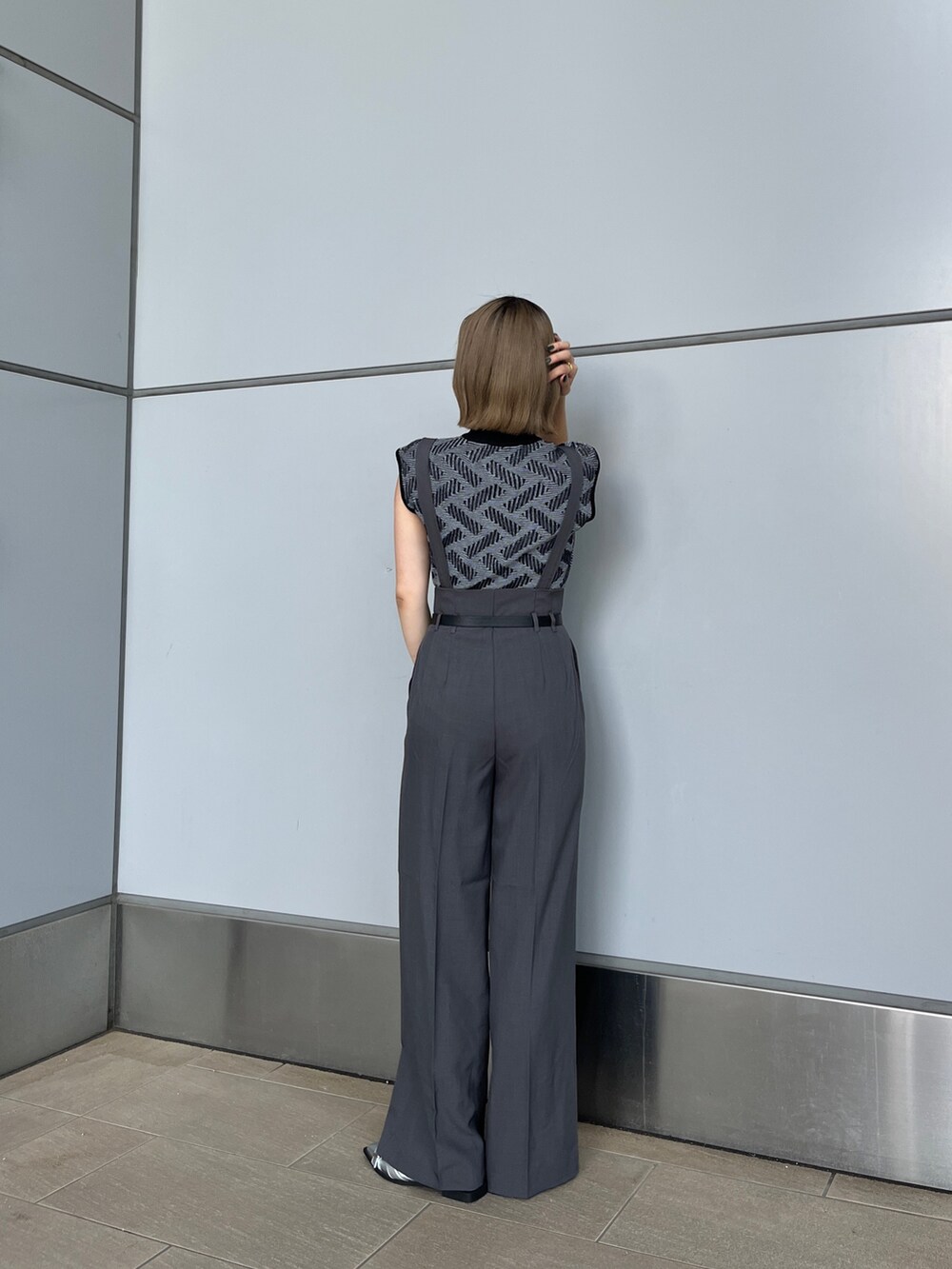 ブラック系のニット/セーター、グレー系のその他パンツ、シルバー系のパンプスを着用したレディースの夏コーディネートの3枚目の写真