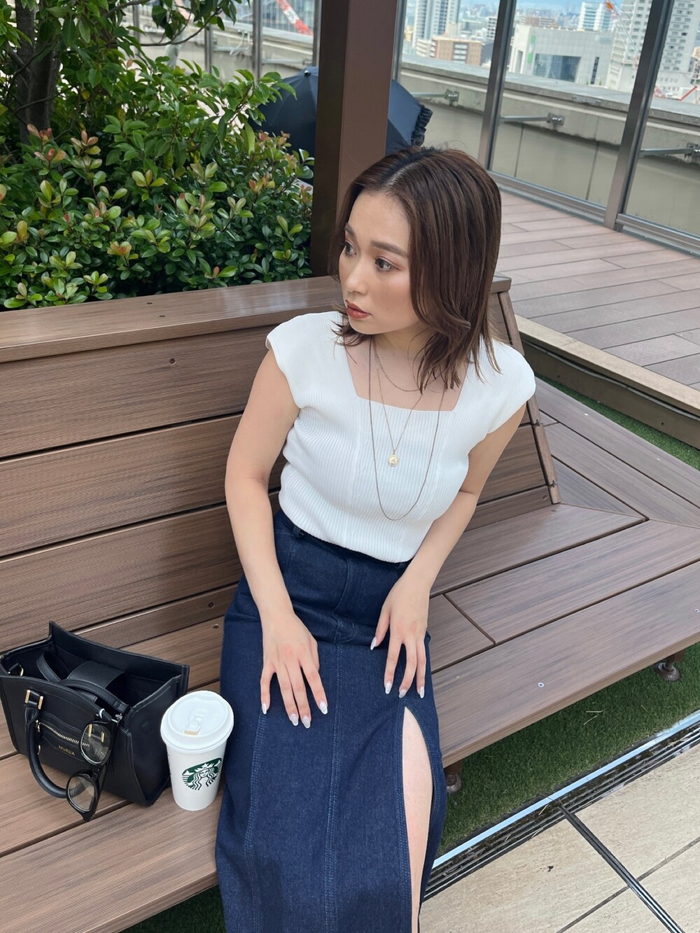 ホワイト系のタンクトップ、ブラック系のスカートを着用したレディースの夏コーディネートの2枚目の写真