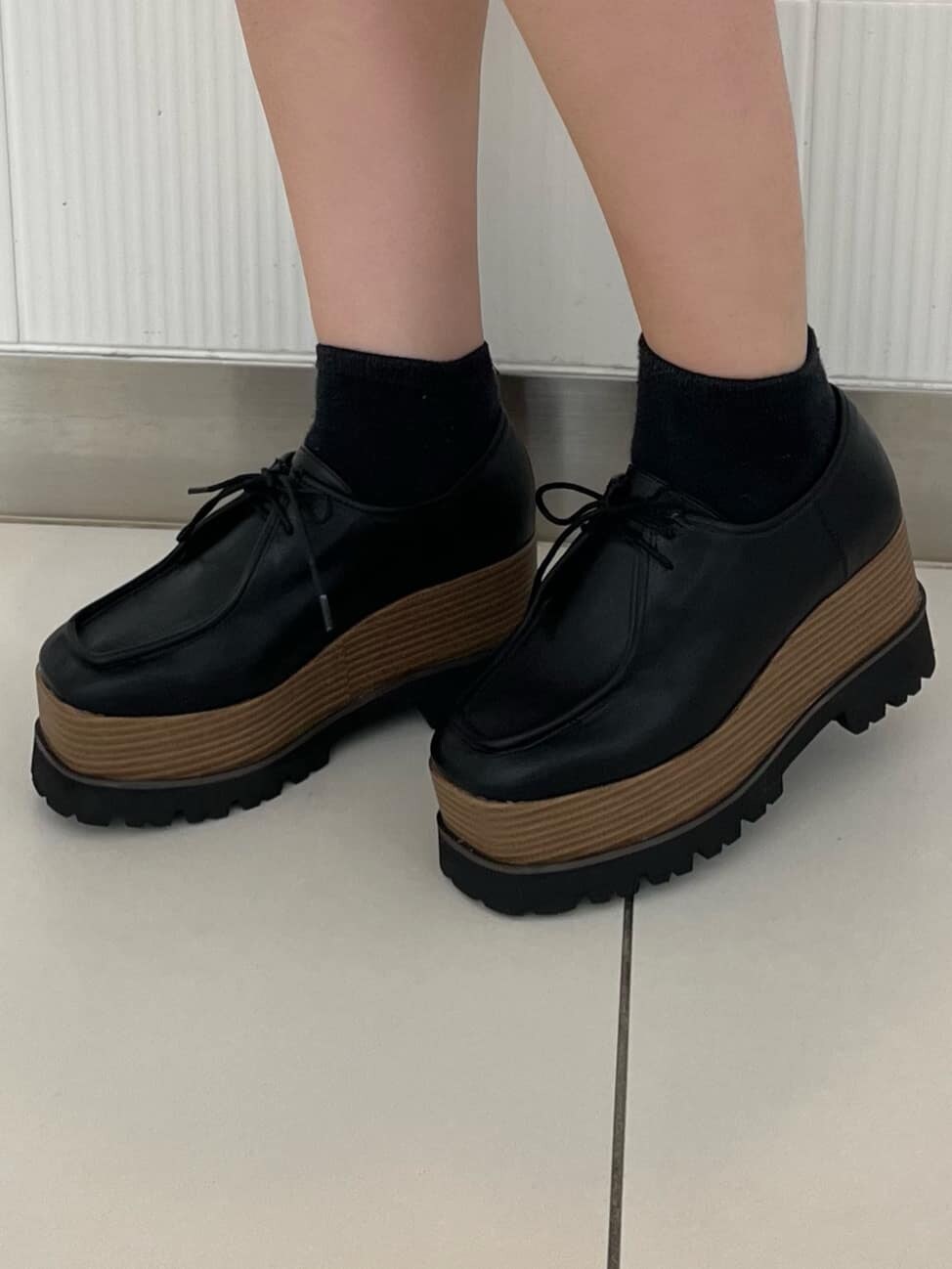 ブラック系のワンピース、ホワイト系のショルダーバッグ、ブラック系のローファーを着用したレディースの夏コーディネートの8枚目の写真