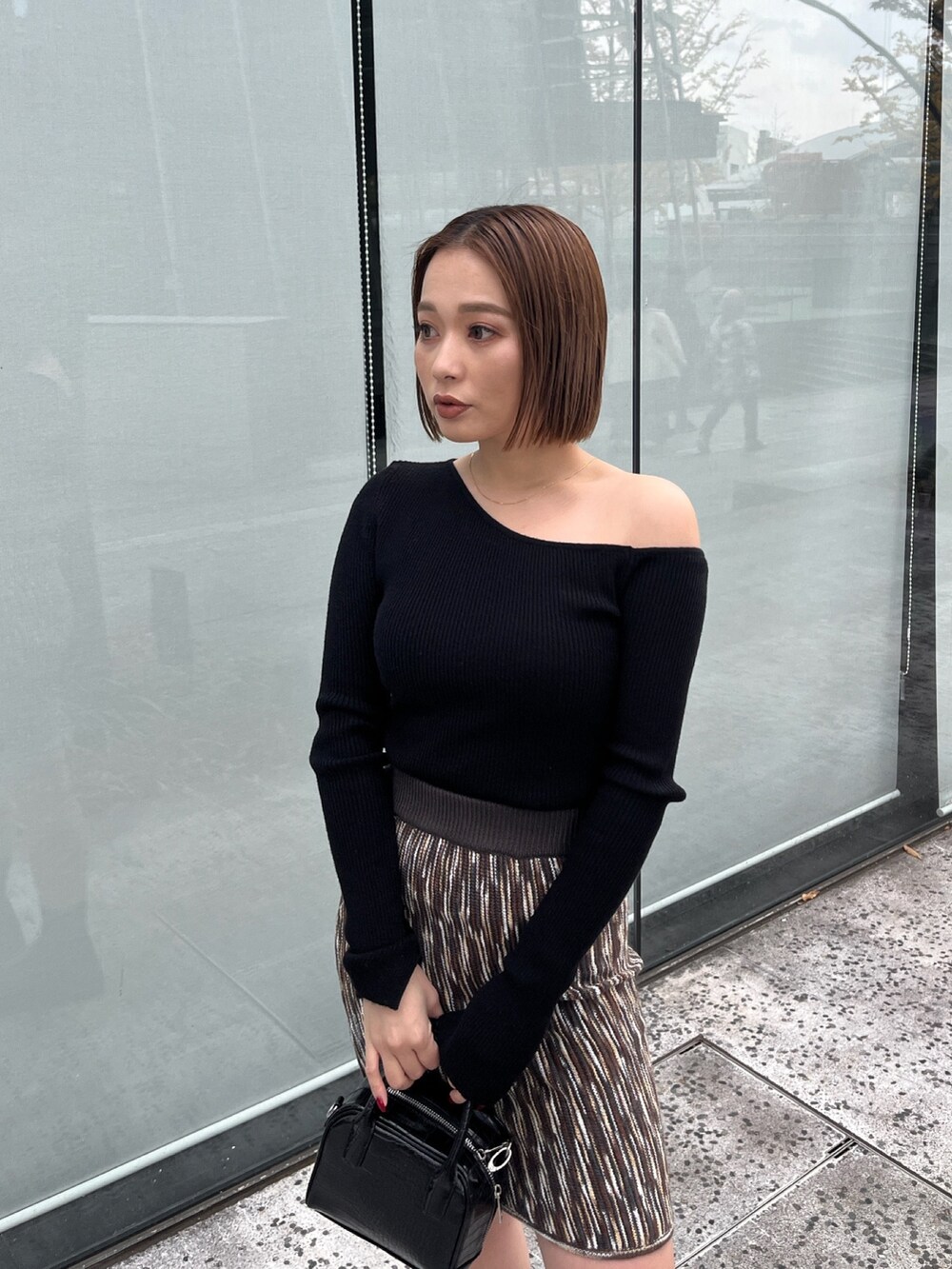 ブラック系のニット/セーター、ブラウン系のスカートを着用したレディースの冬コーディネートの3枚目の写真