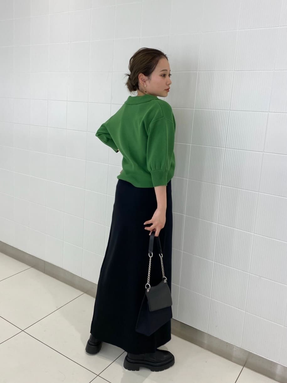 ブラック系のブーツ、ブラック系のハンドバッグ、ブラック系のスカートを着用したレディースの春コーディネートの4枚目の写真