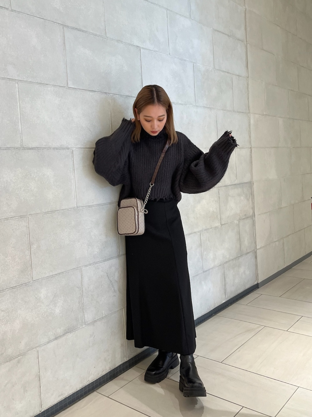 グレー系のニット/セーター、その他のショルダーバッグ、ブラック系のスカートを着用したレディースの秋コーディネートの5枚目の写真
