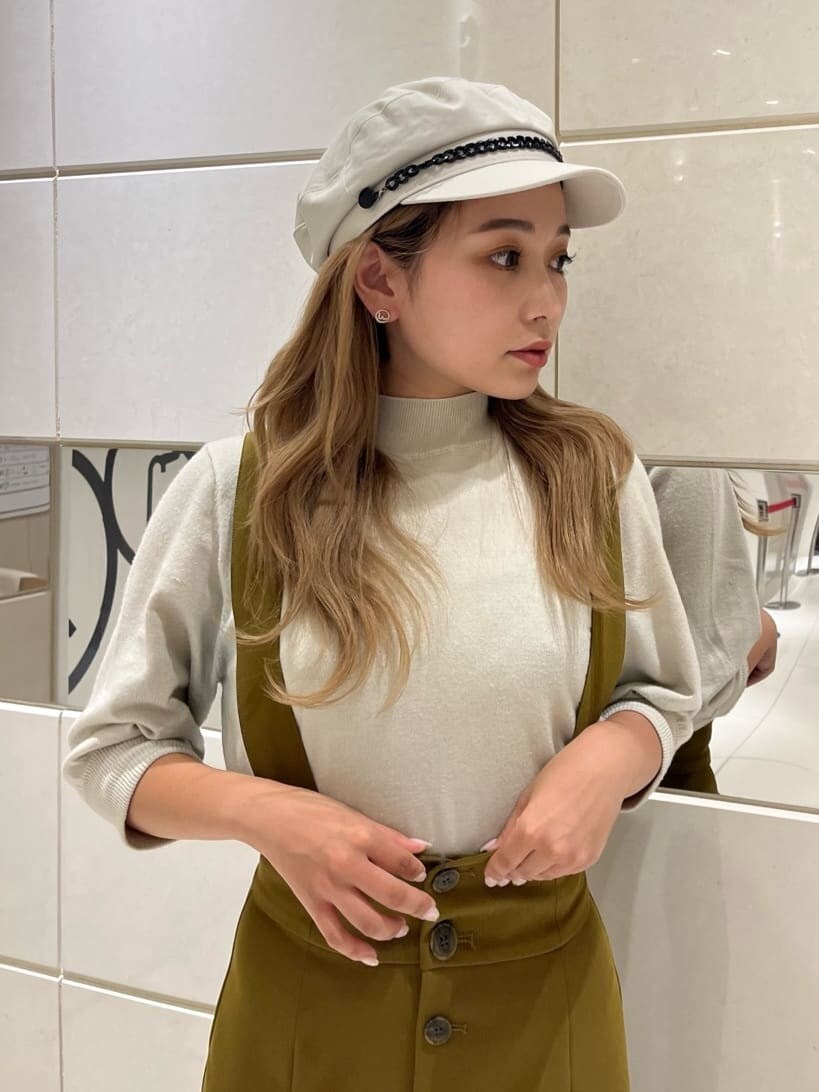 イエロー系のワンピース、ブラック系のブーツ、ホワイト系のニット/セーターを着用したレディースの秋コーディネートの5枚目の写真