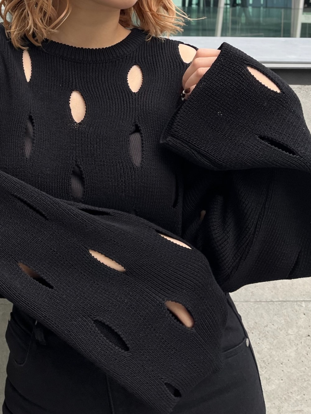 ホワイト系のブルゾン、ブラック系のニット/セーター、ブラック系のデニムパンツを着用したレディースの冬コーディネートの9枚目の写真