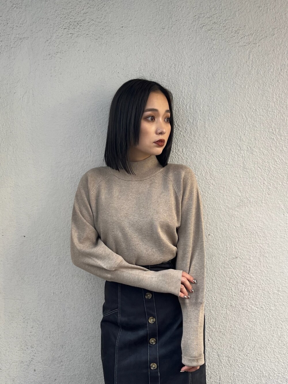 ベージュ系のニット/セーター、ホワイト系のブルゾン、ブラック系のブーツを着用したレディースの夏コーディネートの4枚目の写真