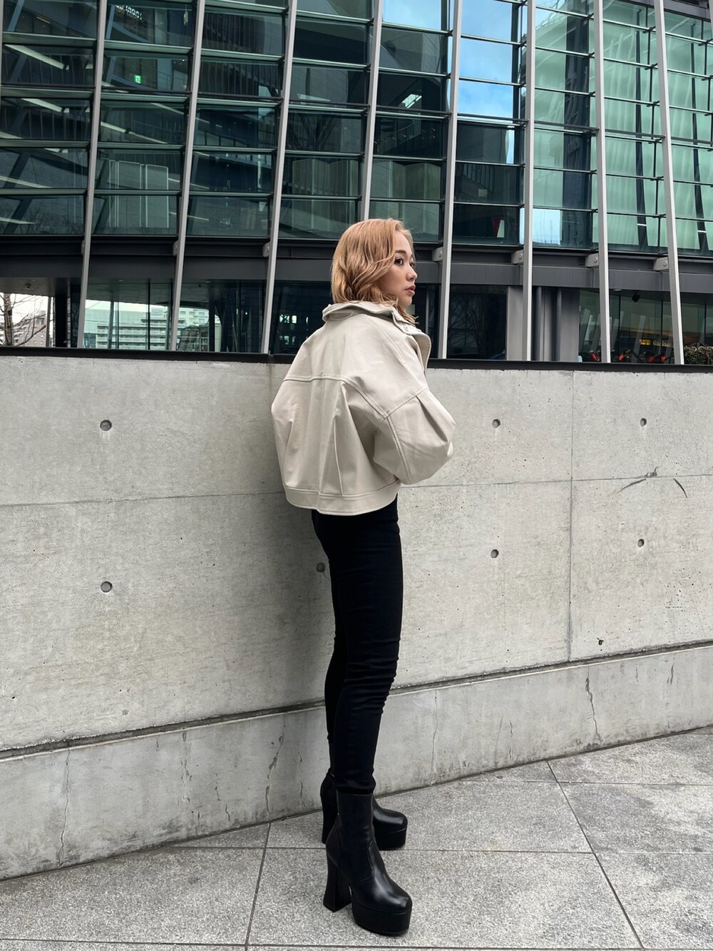 ホワイト系のブルゾン、ブラック系のニット/セーター、ブラック系のデニムパンツを着用したレディースの冬コーディネートの2枚目の写真