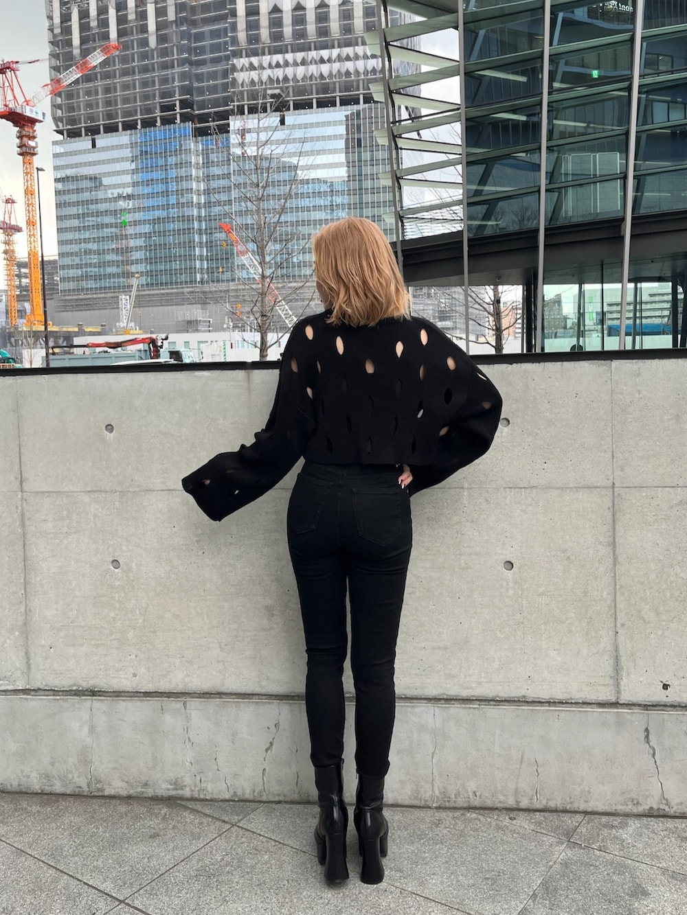 ホワイト系のブルゾン、ブラック系のニット/セーター、ブラック系のデニムパンツを着用したレディースの冬コーディネートの5枚目の写真