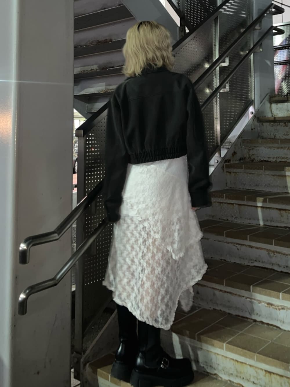 ブラック系のブーツ、ブラック系のブルゾンを着用したレディースの春コーディネートの3枚目の写真