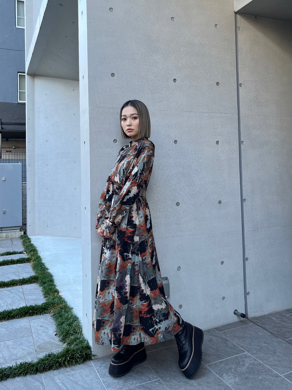 グレー系のブルゾン、ブラウン系のワンピース、ブラック系のブーツを着用したレディースの秋コーディネートの6枚目の写真