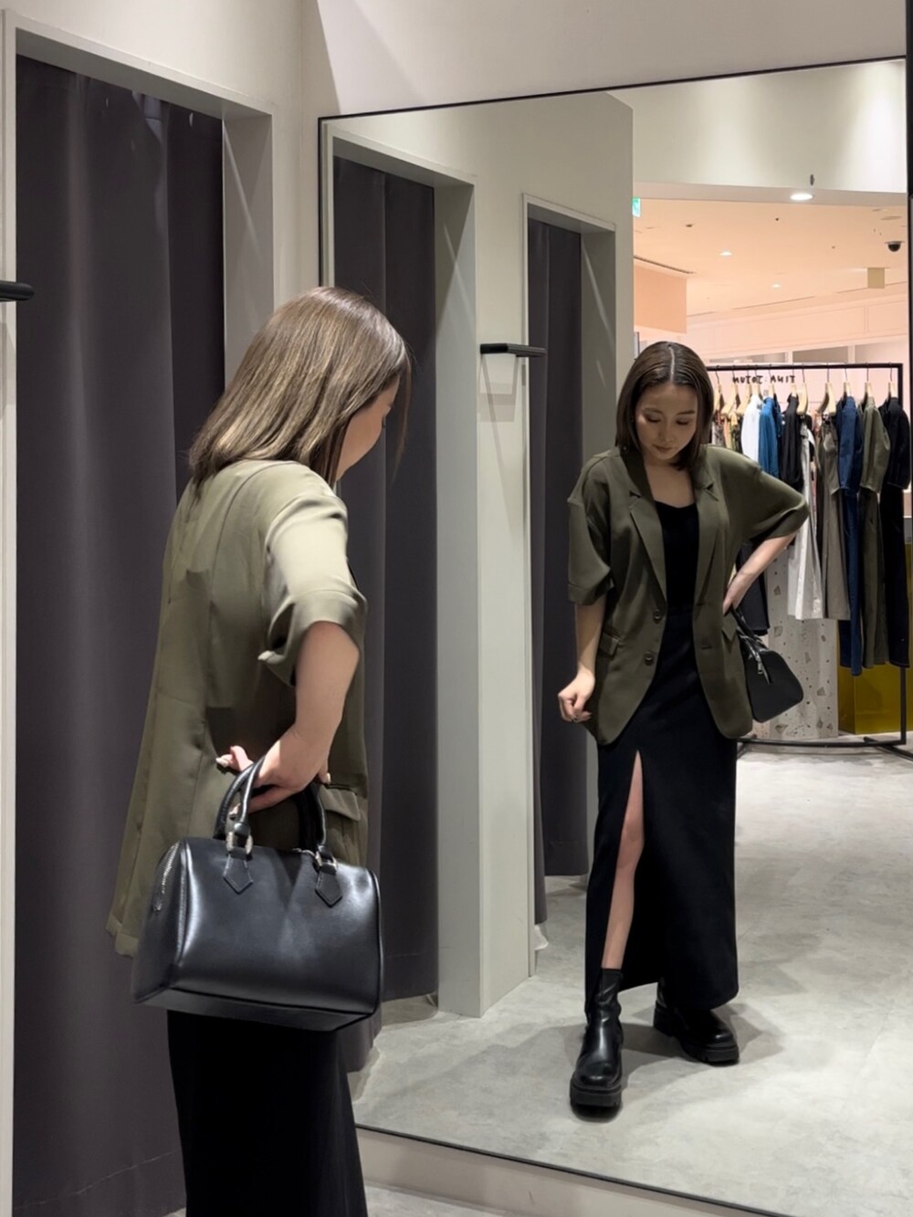 ブラウン系のテーラードジャケット、ブラック系のニット/セーター、ブラック系のスカートを着用したレディースの春コーディネートの2枚目の写真