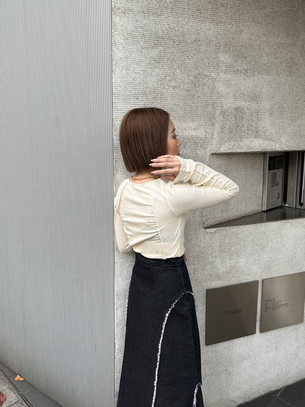 ホワイト系のTシャツ/カットソー、ブラック系のデニムスカートを着用したレディースの秋コーディネートの5枚目の写真