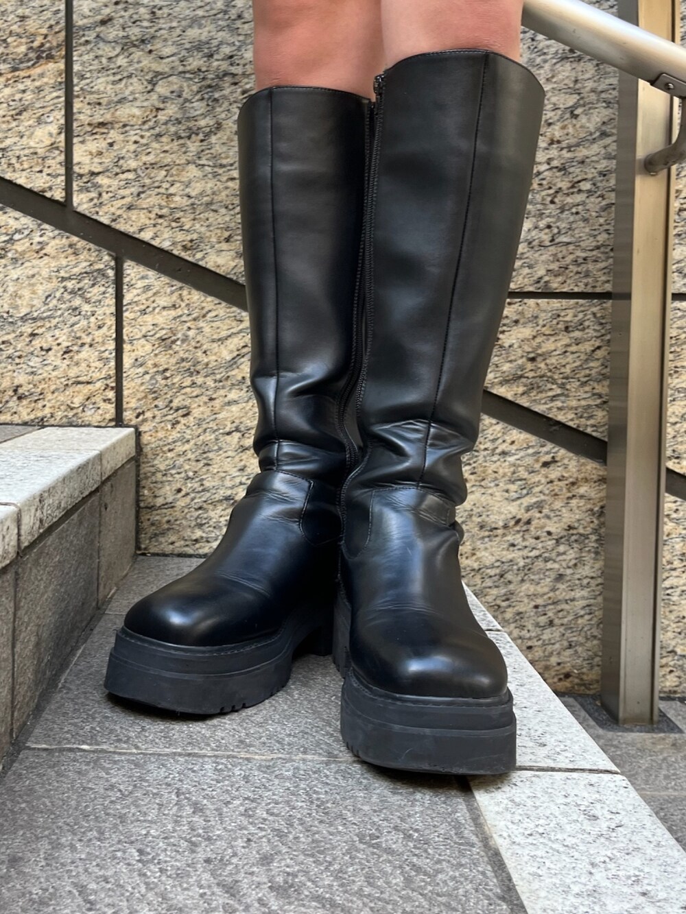 ブラック系のライダースジャケット、グレー系のパーカー、ブラック系のブーツを着用したレディースの秋コーディネートの10枚目の写真