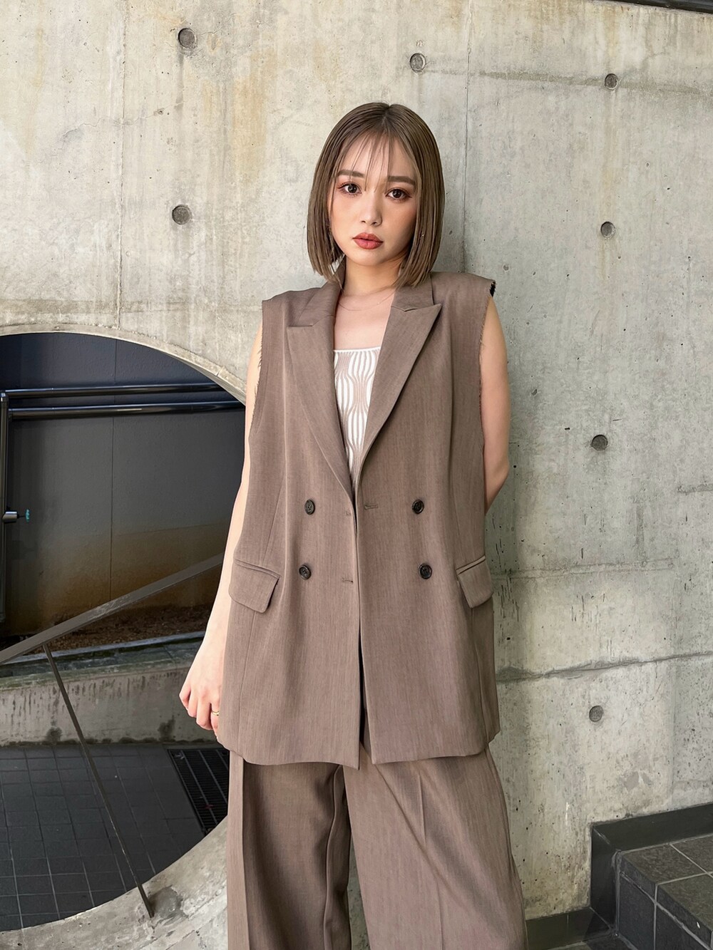 ブラウン系のベスト、ホワイト系のタンクトップ、ブラウン系のその他パンツを着用したレディースの夏コーディネートの4枚目の写真