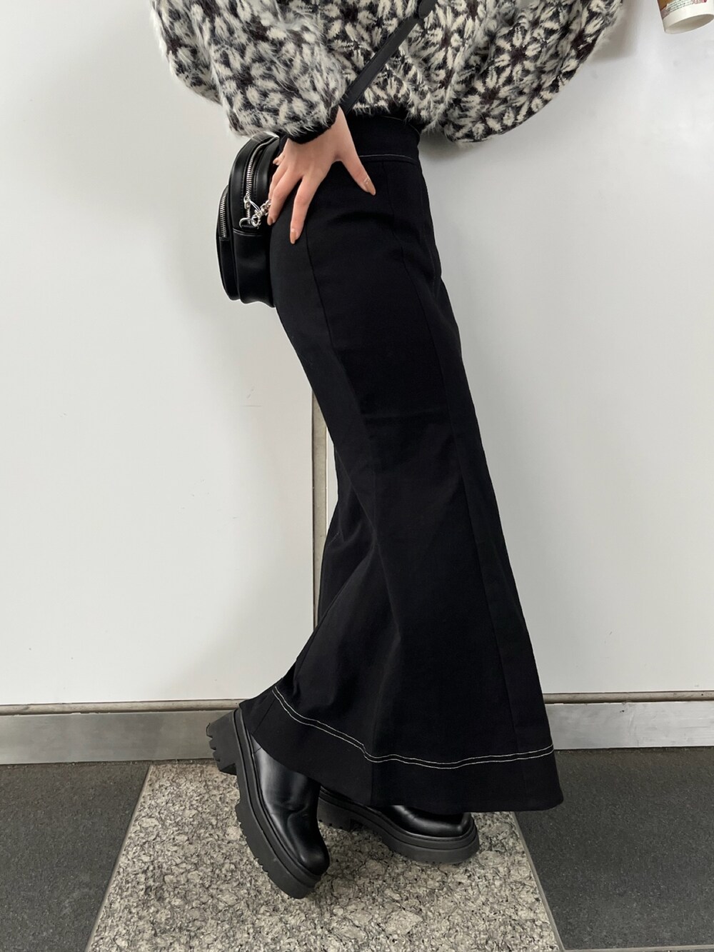 ブラック系のニット/セーター、ブラック系のスカート、ブラック系のショルダーバッグを着用したレディースの秋コーディネートの8枚目の写真