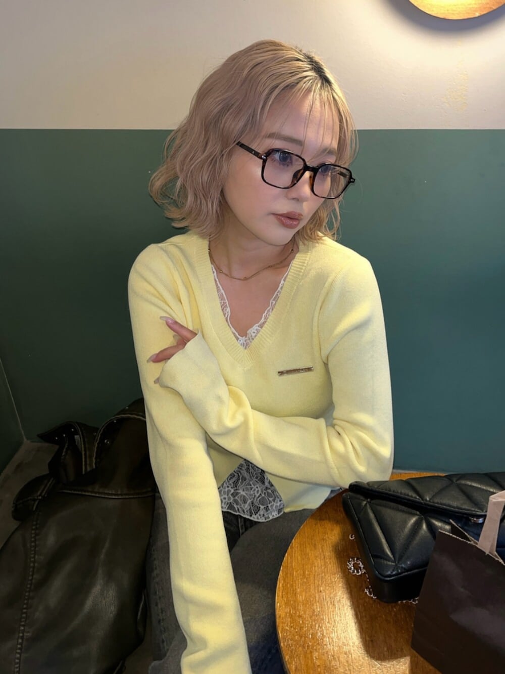 ブラック系のブーツ、イエロー系のニット/セーターを着用したレディースの春コーディネートの5枚目の写真