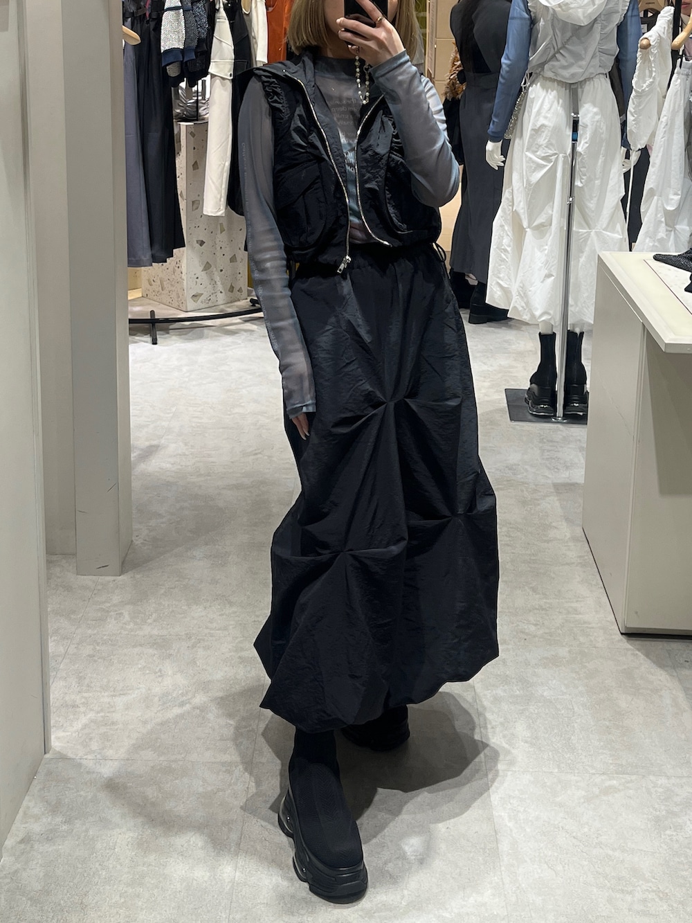 ブラック系のスカート、ブラック系のブーツ、グリーン系のTシャツ/カットソーを着用したレディースの春コーディネートの3枚目の写真