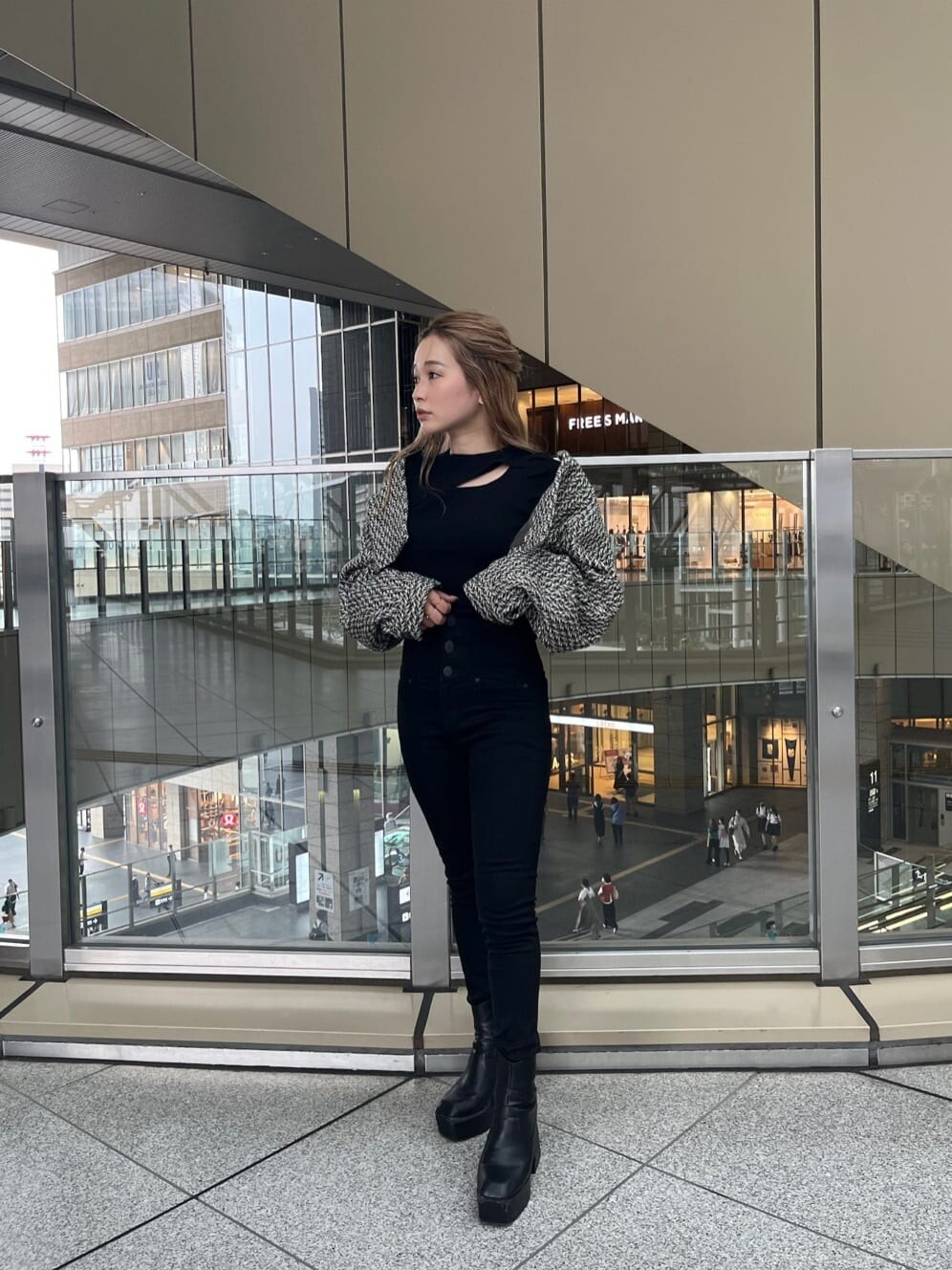 ブラック系のデニムパンツ、ブラック系のニット/セーター、ベージュ系のトレンチコートを着用したレディースの夏コーディネートの7枚目の写真