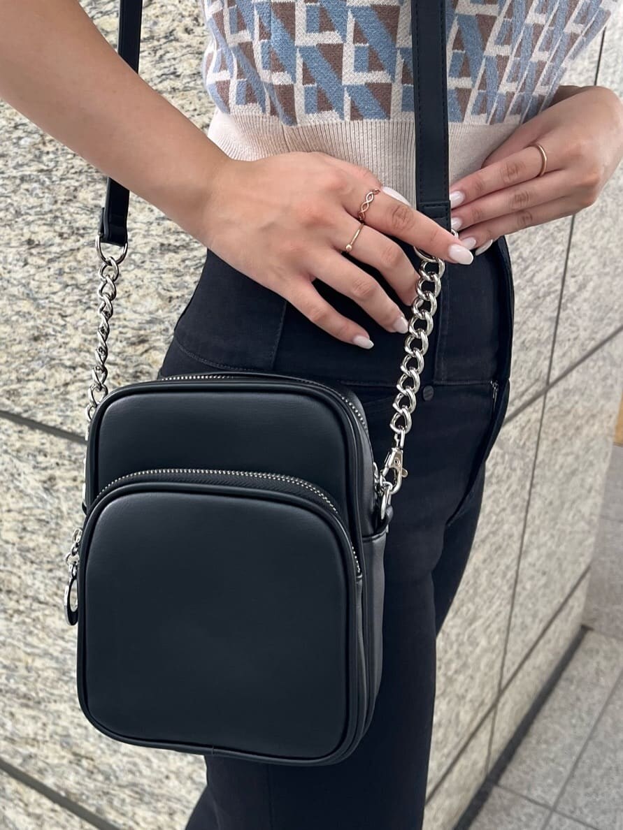 ブラック系のデニムパンツ、ブラック系のショルダーバッグ、ホワイト系のニット/セーターを着用したレディースの夏コーディネートの7枚目の写真